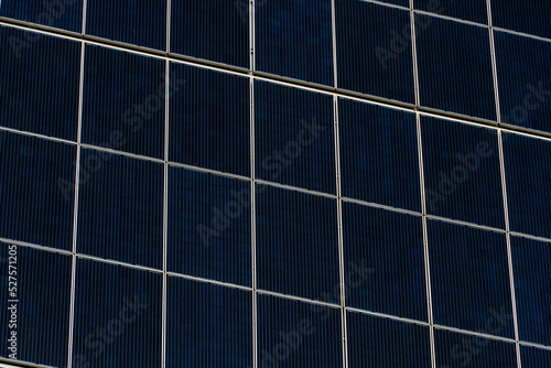 close-up of solar panels. Renewable energy. Environmentally safe sources of electricity. Passing clouds are reflected in the glass surface of the solar panels.