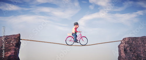 Foto Man ride a cycle and balancing a between two mountain peaks.