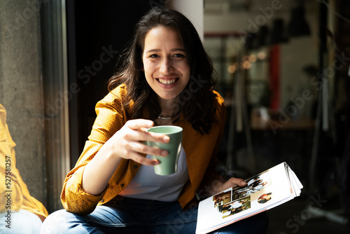 Young businesswoman drinking coffee in her office. Woman enjoy in coffee break