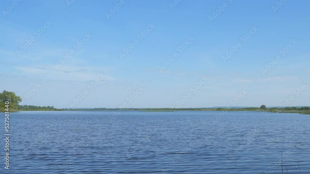 View of a large summer river or lake. Water on the lake with light ripples.Summer landscape with a river. Camera panning