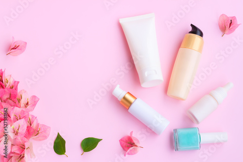 Decorative cosmetics set with pink bougainvillea flowers on pink background