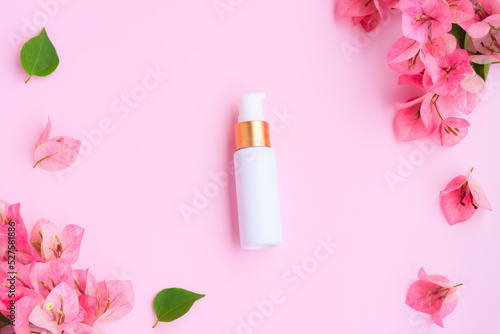 Cosmetic bottle tube with pink bougainvillea flowers on pink background