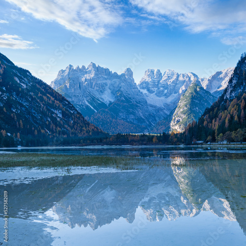Autumn peaceful alpine lake Durrensee or Lago di Landro. Snow-capped Cristallo rocky mountain group behind, Dolomites, Italy, Europe. Seasonal and nature beauty concept. People and cars unrecognizable