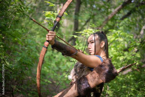 Beautiful asian woman an archer with the bow is hunting in the forest concept.