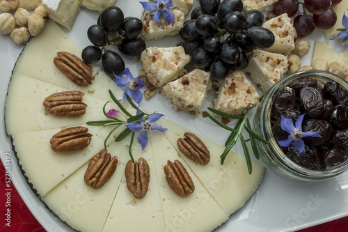 selection  of cheeses with grapes and edible flowers