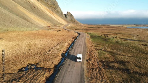 Aerial shot of a van driving on a road in Iceland