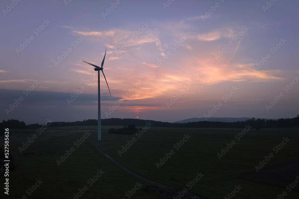 Obraz premium Aerial, scenic view of wind power plant silhouette against colorfull sunset sky. Drone inspection of wind-powered electrical generator.