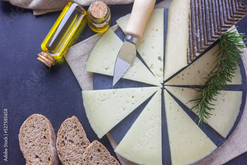 Foto Queso curado manchego sobre un plato circular con pan y ecite