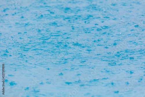 Surface of blue water in heavy rain.