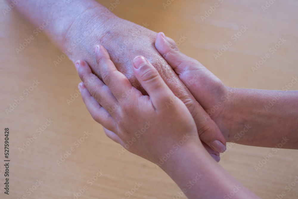Hands of a small child tenderly holding the hands of his grandmother Hands of a small child tenderly holding the hands of his grandmother