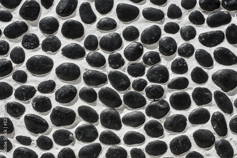 Wall closeup hand construction river round black stones closeup Wall closeup hand construction river round black stones closeup
