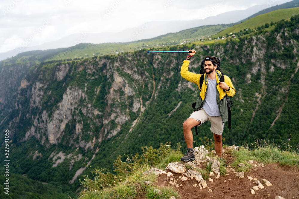 Obraz premium Active hiker hiking, enjoying the view, looking at mountain landscape