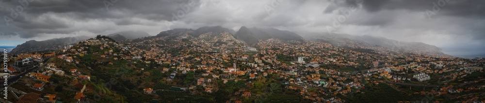 Aerial panoramic view of Funchal city from Miradouro Pico dos Barcelos. Madeira, Portugal. Foggy and rainy weather. October 2021