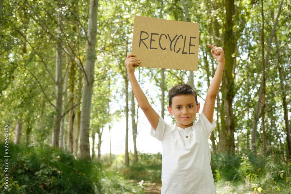 child displays message to recycle. Young activist concerned about ecology and nature conservation - obrazy, fototapety, plakaty 