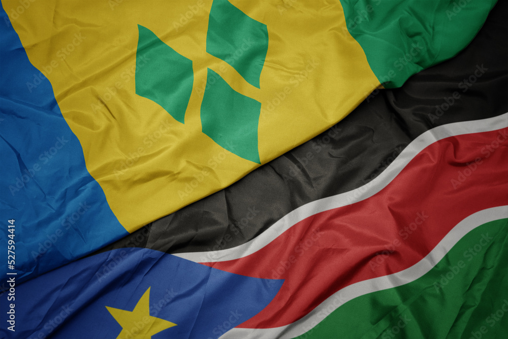 Fototapeta premium waving colorful flag of south sudan and national flag of saint vincent and the grenadines.