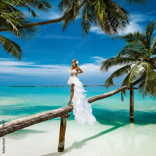 Bride on the beach. Stylish female model in elegant long gown dress on the Maldives beach. Elegance. Bride on Maldives. Bridal fashion. Classy woman in amazing ruffle white dress. Luxury travel