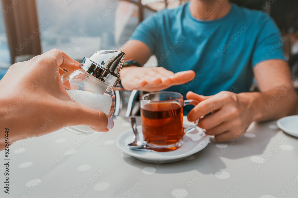 Man is on a healthy diet and refuses to add sugar to his glass of tea. The concept of diseases from an excess of fast carbohydrates and diabetes