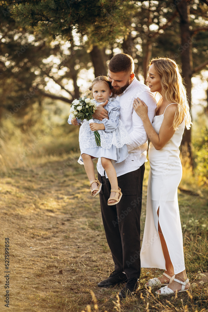 Family with their little daughter together in forest Family with their little daughter together in forest