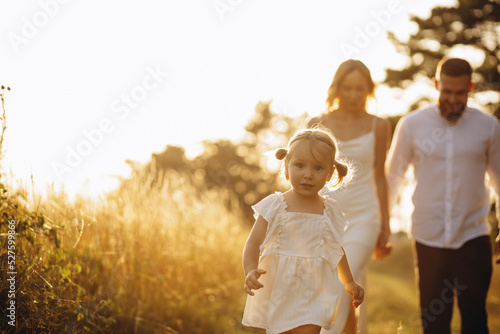 Family with their little daughter together in forest