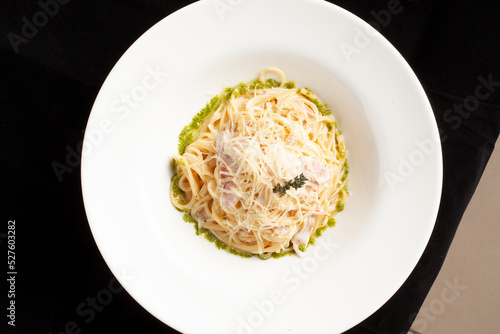 Pasta with bacon and cheese in a plate. On a dark background. photo