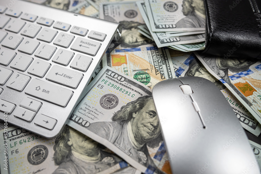 stack of many American dollars on a white laptop keyboard. stack of many American dollars on a white laptop keyboard.