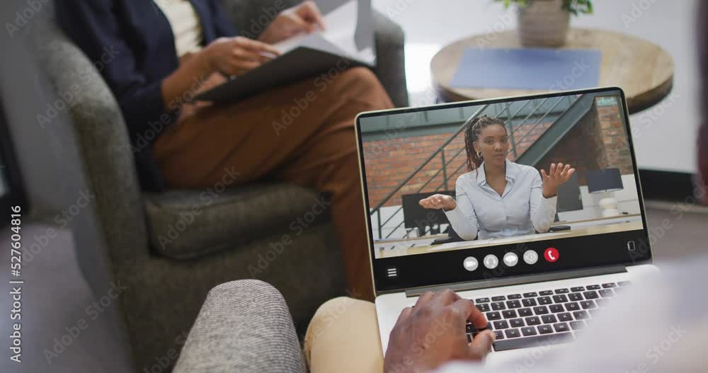 African american man using laptop for video call, with business colleague on screen