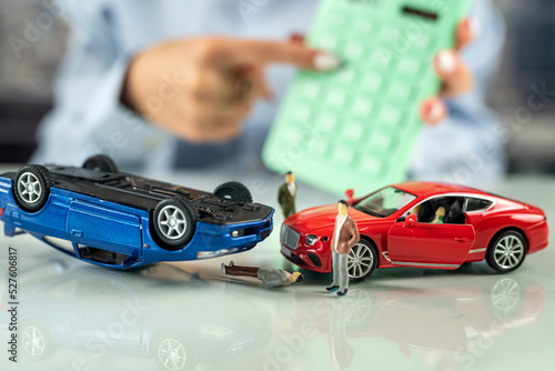 woman office worker sits at a table with a simulation of an accident of two cars.