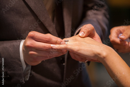 Close up of loving bride and groom putting a beautiful wedding ring to the beloved partner  marry me concept. High quality photo