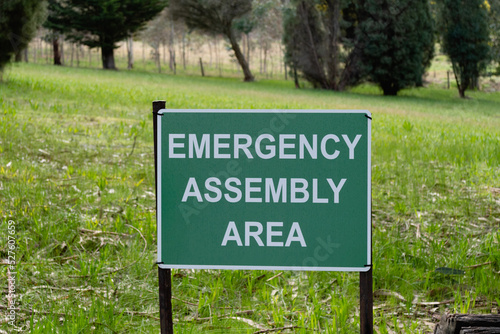 Road sign Emergency Assembly Area plate white on green in the park in Australia