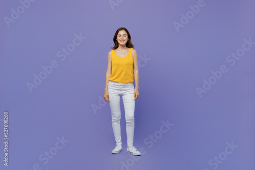 Full body young smiling happy fun caucasian confident cool woman 20s she wear yellow tank shirt look camera isolated on plain pastel light purple background studio portrait. People lifestyle concept.