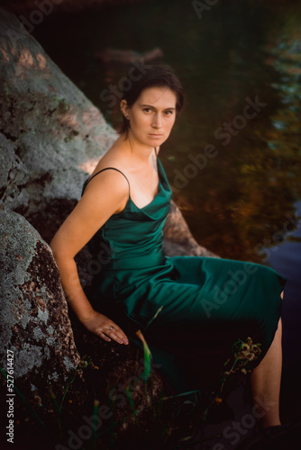 Beautiful young girl in an emerald dress in nature