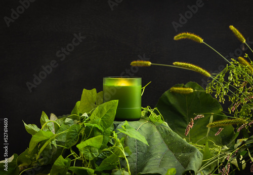 Photography object photo of a candle on a black background, the candle stands on a variety o