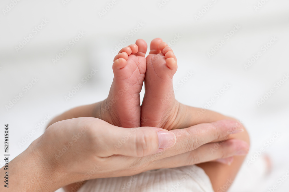Mother touching and holding baby feet with love. Infant Tiny baby feet with mom hand relax and comfortable. Good moment of mother and baby warmth hearth. Baby care Mother touching and holding baby feet with love. Infant Tiny baby feet with mom hand relax and comfortable. Good moment of mother and baby warmth hearth. Baby care