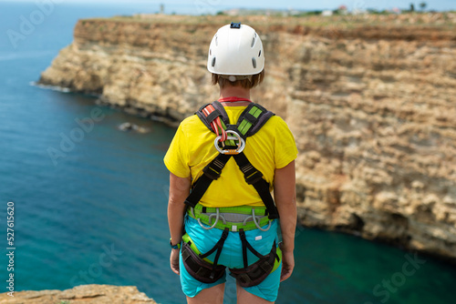 Woman in a protective helmet and insurance before jumping off a cliff. Rope jumping.