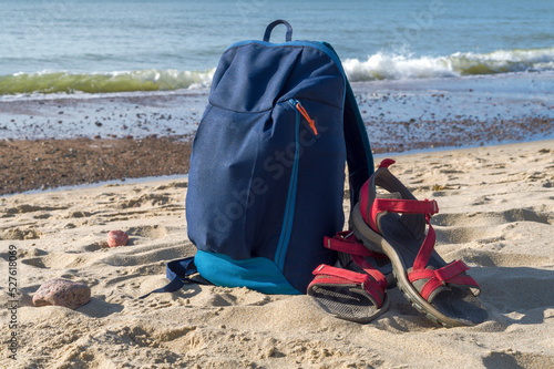 Backpack and sandals against the backdrop of nature. Walking along the seashore. © SeagullNady