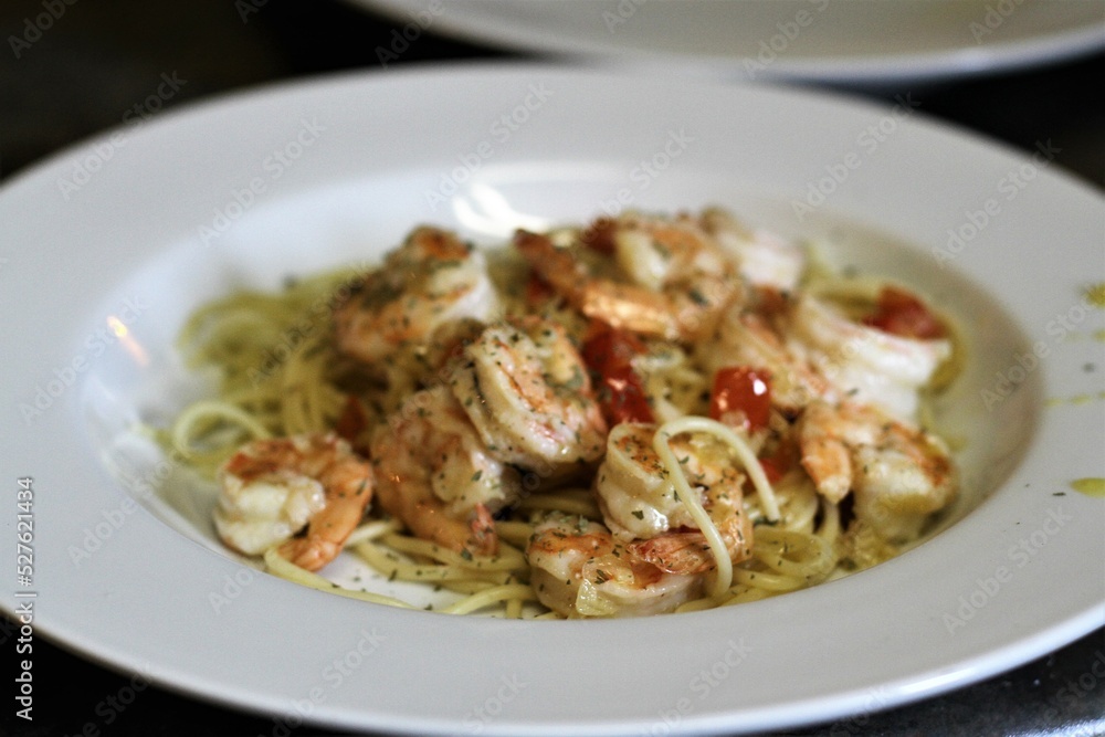 Spaghetti alla olio with shrimp in white shallow bowl