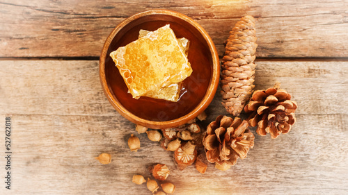 Honey and honeycomb with wooden spoon on wooden table