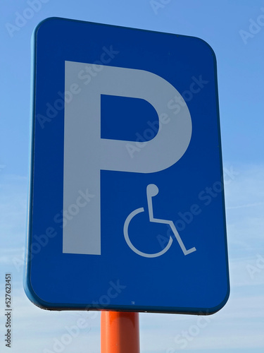 Vertical shot on a blue panel for reserved parking spots for disabled people