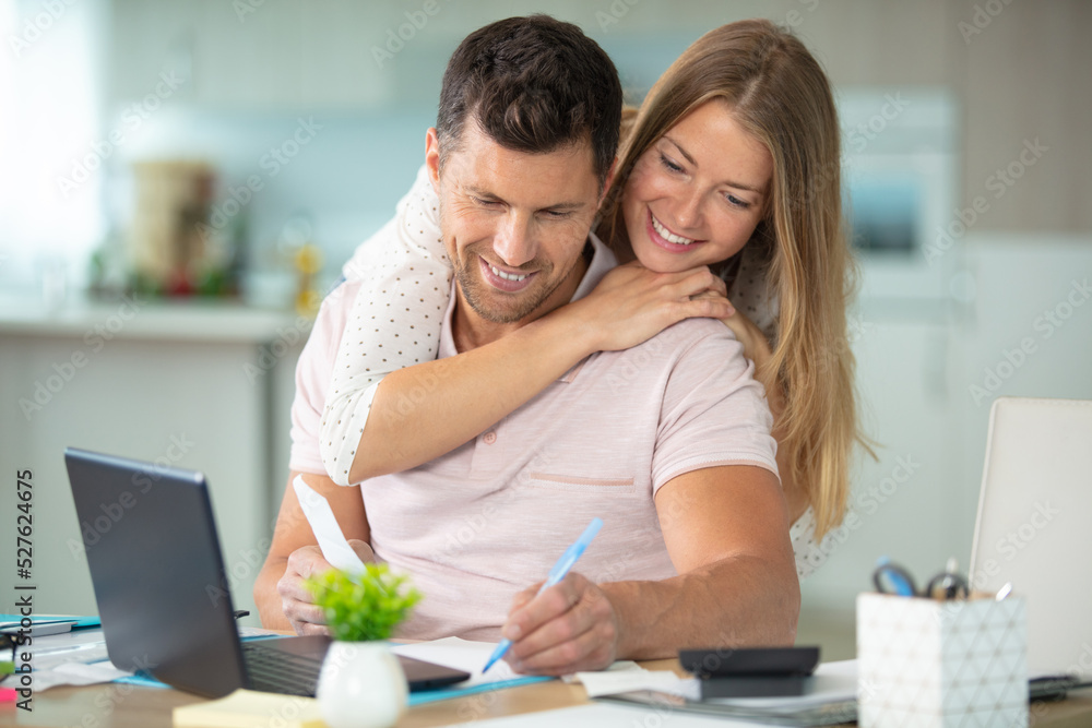 happy couple hugging and working together at home happy couple hugging and working together at home