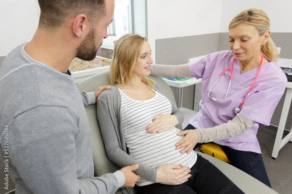 female doctor with pregnant woman and his husband in hospital female doctor with pregnant woman and his husband in hospital