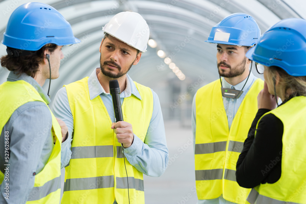 portrait of journalist interviewing engineers portrait of journalist interviewing engineers