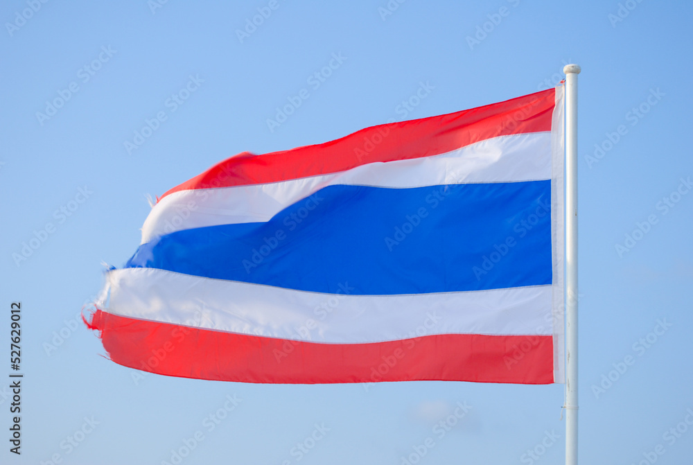 Thai national flag, with the background of clear blue sky Thai national flag, with the background of clear blue sky