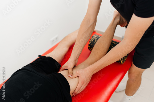 Male therapist massaging of athlete patient - sports physical therapy concept