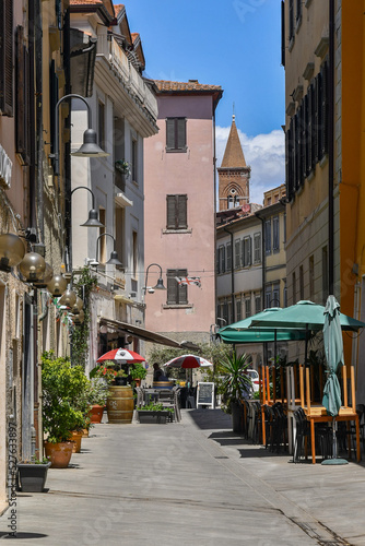A narrow street in the old town of Grosseto with the bell tower of the Church of St Francis in the background, Tuscany, Italy