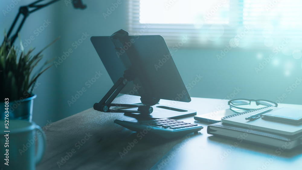 Stylish workplace with telephone and tablet PC on table in home office, beautiful blue fillter Stylish workplace with telephone and tablet PC on table in home office, beautiful blue fillter