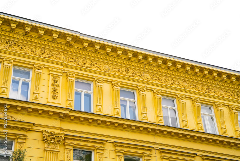 Yellow building facade in Vienna. Colorful real estate with old baroque design. Yellow building facade in Vienna. Colorful real estate with old baroque design.
