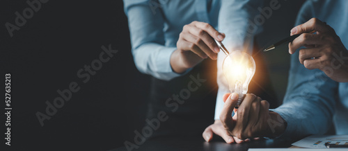 Businessman holds a glowing lamp, Creative new idea. Innovation, brainstorming, strategizing to make the business grow and be profitable. Concept execution, strategy planning and profit management.