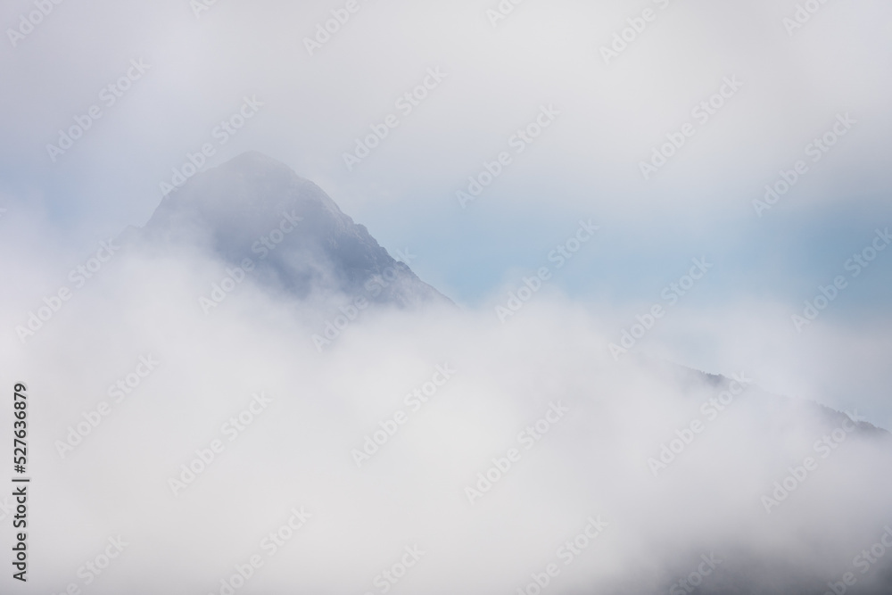 Thick clouds around mountain peak Thick clouds around mountain peak