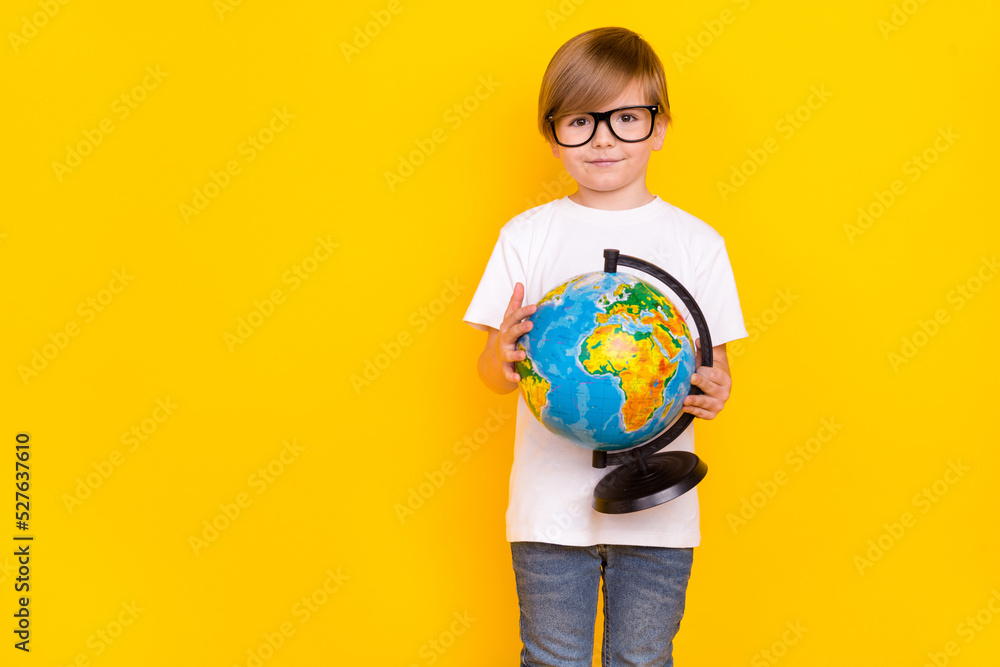 Portrait of handsome cheery intellectual pre-teen boy holding globe copy space explore isolated over bright yellow color background Portrait of handsome cheery intellectual pre-teen boy holding globe copy space explore isolated over bright yellow color background