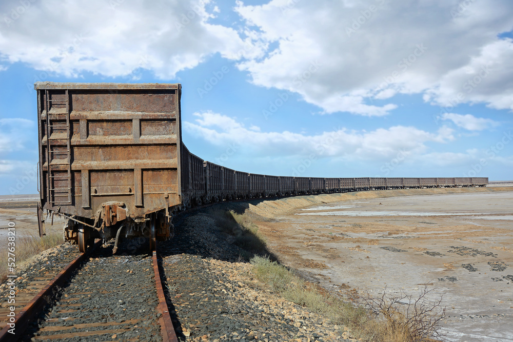 Old railroad and wagons for the transport of technical salt on a salt lake Old railroad and wagons for the transport of technical salt on a salt lake